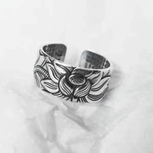 999 Sterling Silver Lotus Heart Sutra open adjustable ring with embossed lotus flower pattern, front oblique view on white fabric background