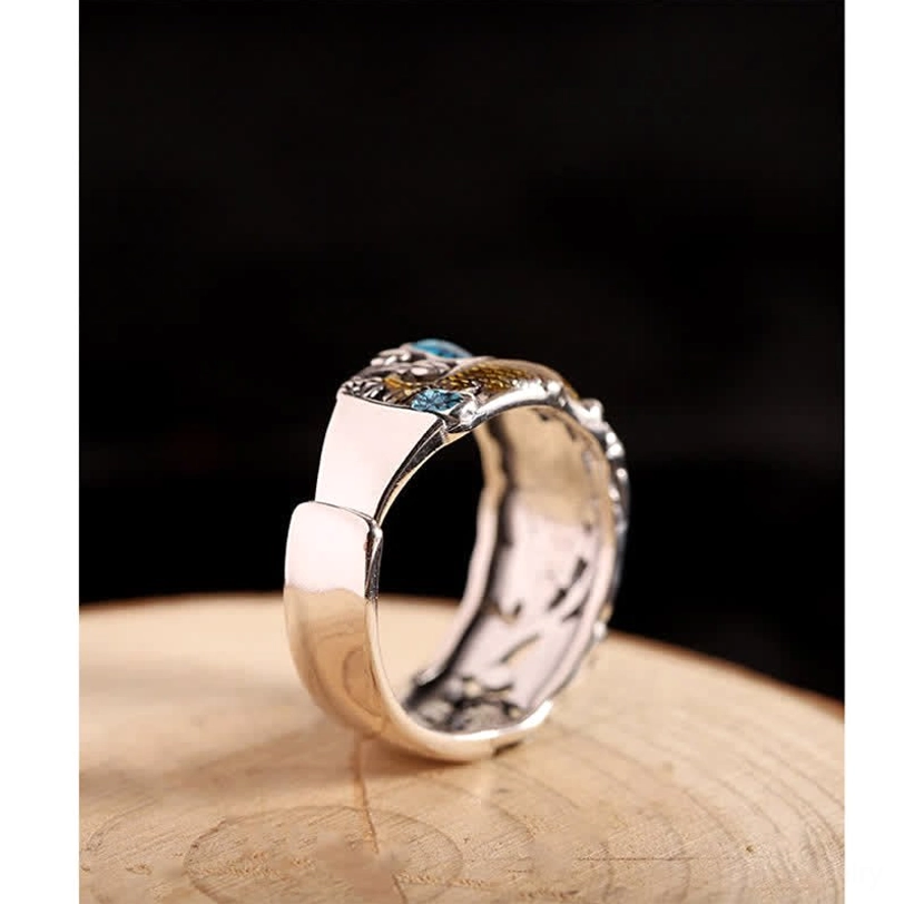 Side oblique view of lotus koi fish sterling silver ring on wooden base, highlighting the band pattern and texture