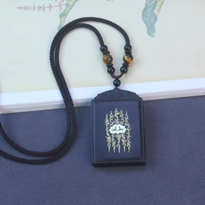 Handcrafted wooden lotus necklace with braided black cord on vintage book background, Tibetan artisan jewelry