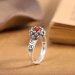 925 sterling silver lotus red agate ring with Sanskrit engravings, side view on vintage background