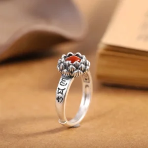 925 sterling silver lotus red agate ring with Sanskrit engravings, side view on vintage background