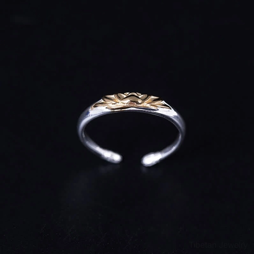 Tibetan lotus ring front overhead view displaying full embossed gold lotus top design on open silver cuff