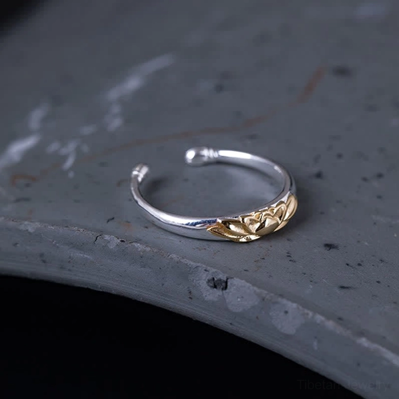 Sterling silver lotus cuff ring oblique overhead view displaying embossed gold lotus and open adjustable split design