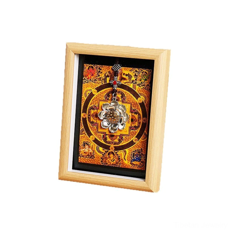 Lotus thangka mandala frame on white background showing light wood frame with orange mandala design and silver lotus pendant detail