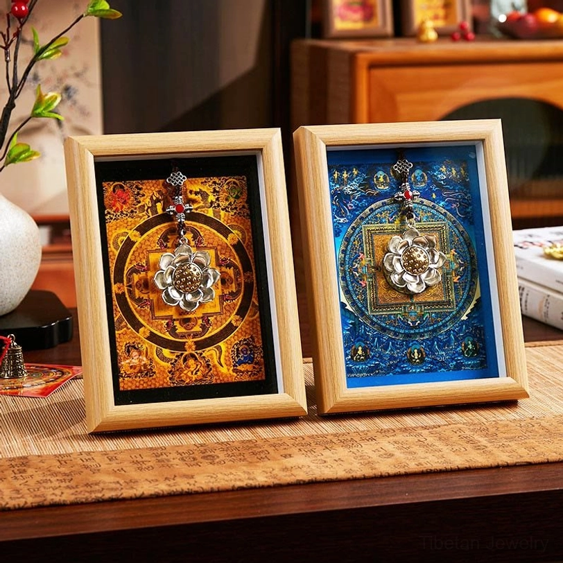 Two lotus thangka mandala frames side by side, left with orange mandala design and right with blue mandala artwork, both in light natural wood frames