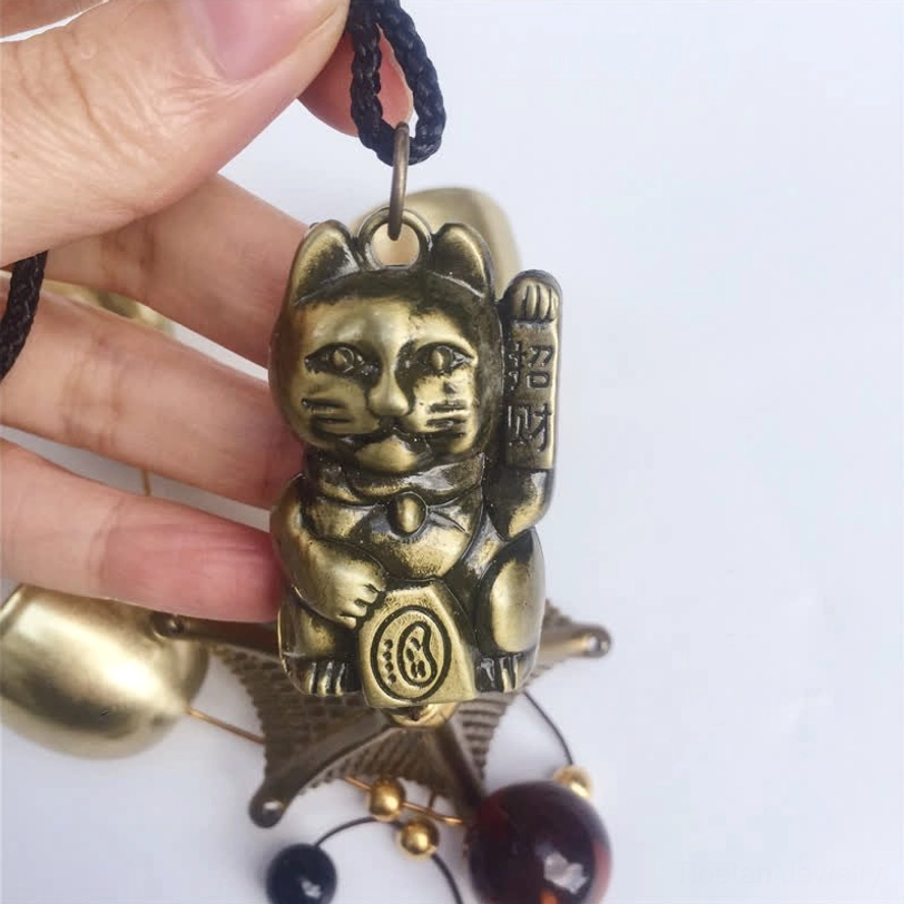 Lucky Cat charm close-up embossed details antique bronze copper metal Tibetan craftsmanship