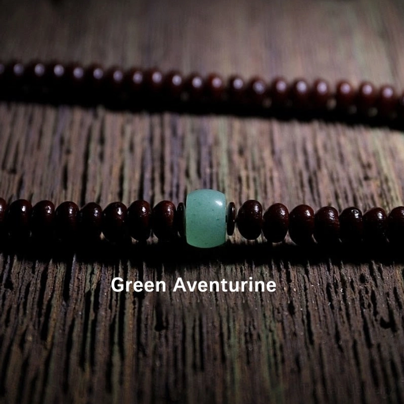 Tibetan mala strand featuring dark brown bodhi seeds and green aventurine accent bead