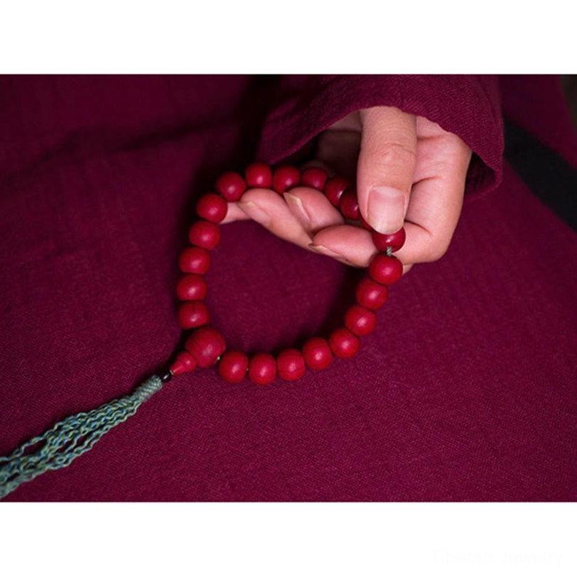 Fingers adjusting and counting abelia biflora mala beads meditation practice close-up