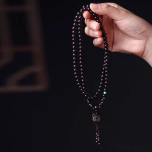 Handheld 108 prayer mala beads with tassel and turquoise accent close-up