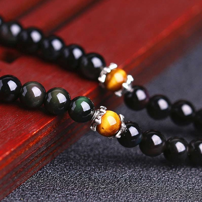 Close-up of black obsidian and tiger eye beads with silver spacer detail on zodiac mala bracelet