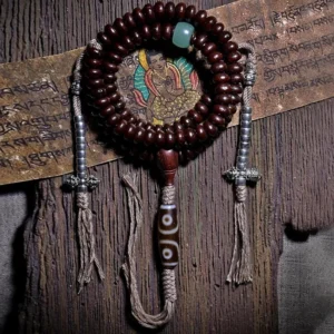 Authentic purple bodhi seed mala beads with silver dorje accents and green aventurine spacer on aged wood
