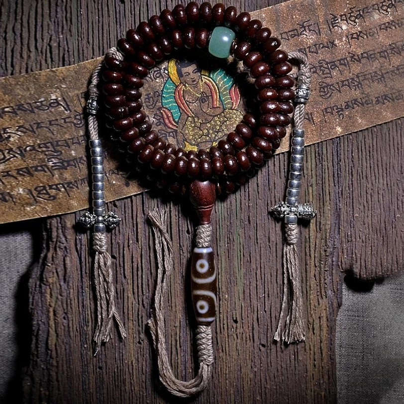 Authentic purple bodhi seed mala beads with silver dorje accents and green aventurine spacer on aged wood