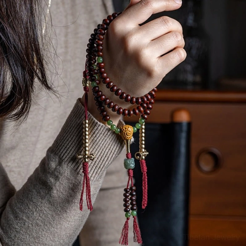 Tibetan mala bracelet worn on wrist showing purple bodhi seeds and hetian jade multi-layer design