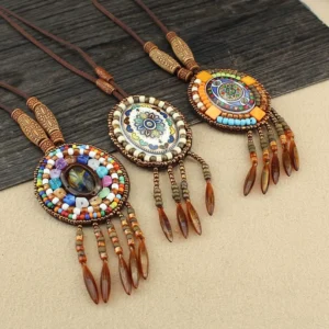 Multiple colorful beaded mandala pendants with leather tassels and wax cord necklaces arranged in bohemian style layout