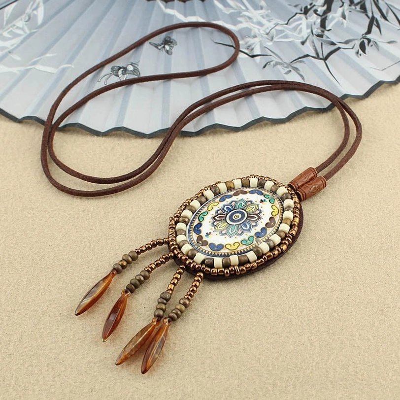 Neutral-toned mandala pendant necklace with beaded tassel details and wax-coated adjustable cord