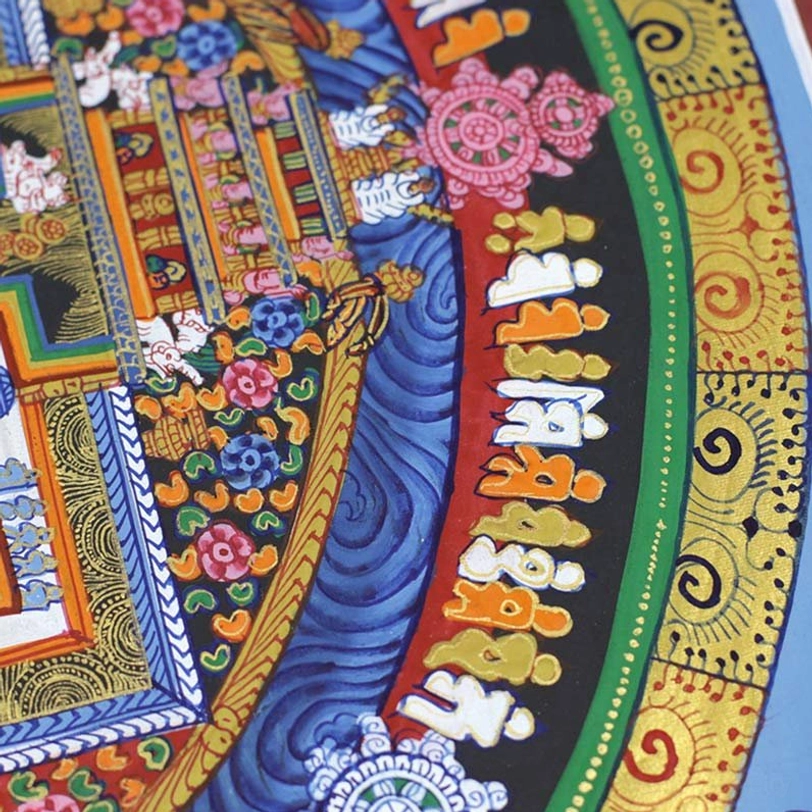 Kalachakra mandala thangka close-up detail showing Buddhist script, dharmachakra symbol and gold filigree accents with swirling blue wave patterns