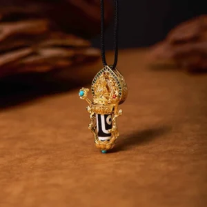 Manjusri Bodhisattva Dzi bead gold pendant necklace with turquoise and red gemstone inlays, front three-quarter view on wooden background