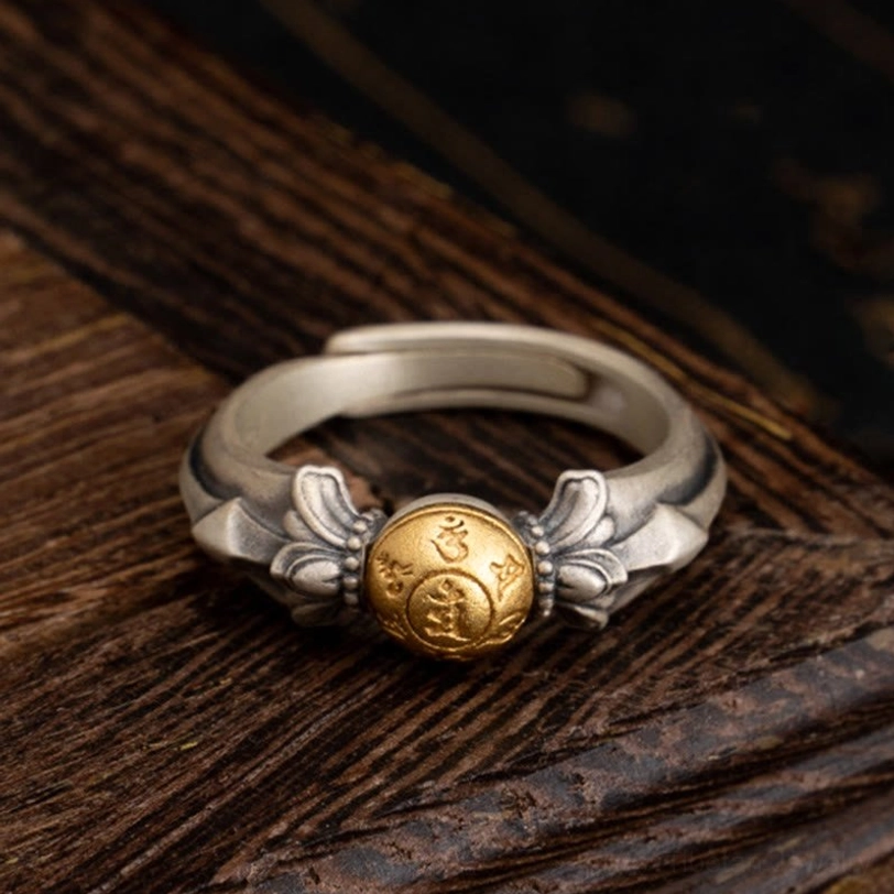 925 sterling silver Manjusri Om Mani Padme Hum adjustable ring with matte finish and gold mantra bead, front view on wooden surface