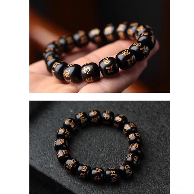 Tibetan Om Mani Padme Hum ebony bracelet resting on palm showing tightly strung bead strand with clear golden sutra markings