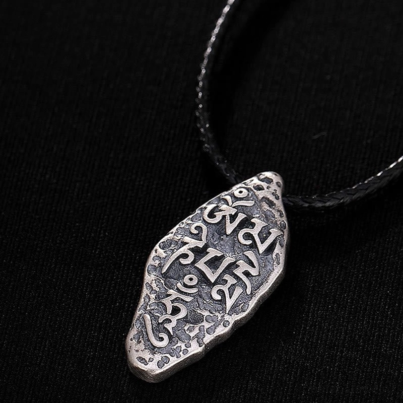 Detailed view of Sanskrit mantra carving on Tibetan sterling silver Buddhist meditation pendant