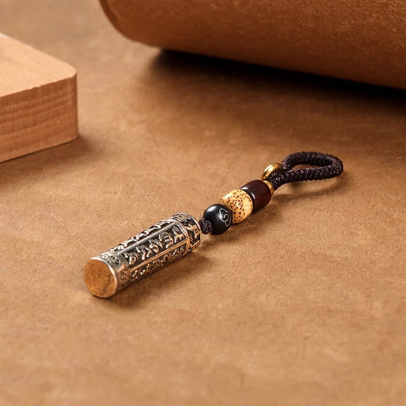 Om Mani Padme Hum keychain detailed side view with silver-engraved tube, wooden cap, and mixed bead lanyard
