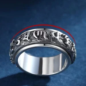 Rotating copper mantra ring top side view with red arrow indicating freely rotatable outer band and embossed Sanskrit mantras