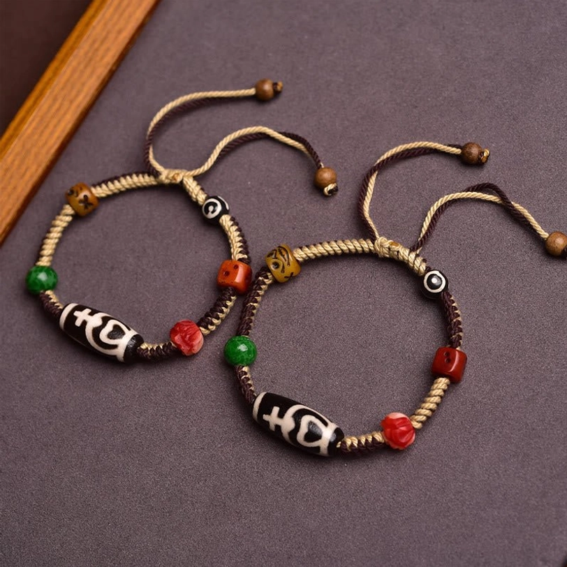 Twin matching nine-eye Tibetan dzi bead bracelets displayed together with adjustable pull cords
