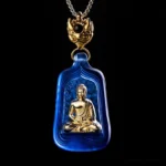 Blue Medicine Buddha Liuli crystal pendant necklace with golden seated Buddha figure and silver chain on black background