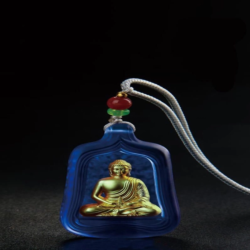 Blue Medicine Buddha crystal pendant on grey braided rope with red and green beads, top-down angled view