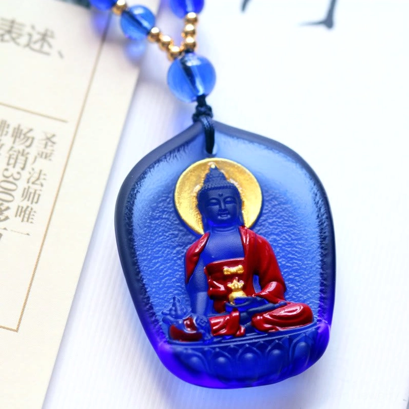 Blue Medicine Buddha Liuli crystal pendant with rounded square glass frame, gold halo, Buddha statue, and blue beaded accent cord