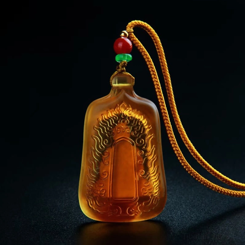 Assorted Medicine Buddha Liuli crystal pendants showing blue, green, and amber colors with handcrafted artisan details