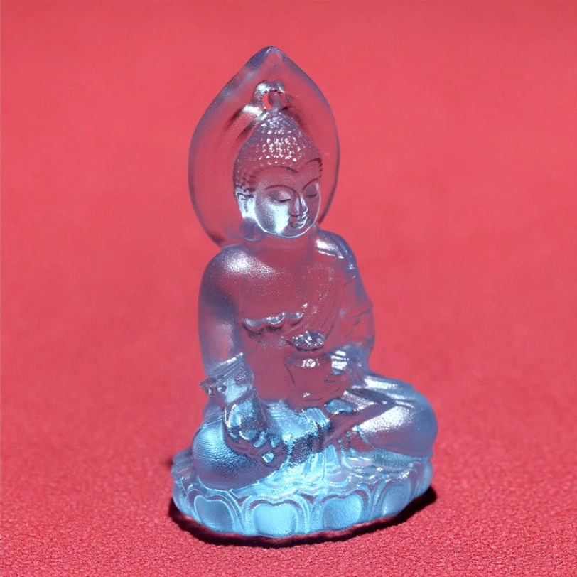Single light blue Liuli Buddha pendant close-up on red background, detailed Buddha carving with lotus throne and sky-blue translucent crystal