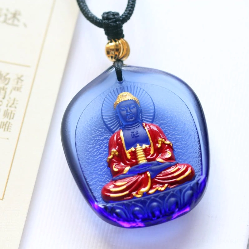 Pagoda Medicine Buddha Liuli crystal pendant with teardrop-shaped dark blue glass, Buddha with ritual vessel, gold lotus throne, and black cord with gold bead