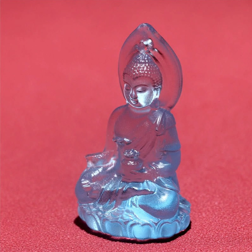 Bhaisajyaguru Buddha pendant front three-quarter side view on red background, Buddha figure holding ritual vessel with glossy smooth crystal finish