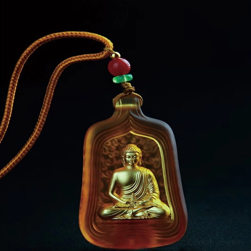 Yellow Medicine Buddha crystal pendant necklace with chain clasp on black background studio shot