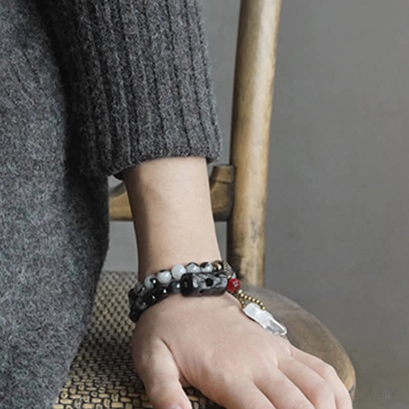 Men's black rutilated quartz couple bracelet on hand showing embossed ebony focal bead