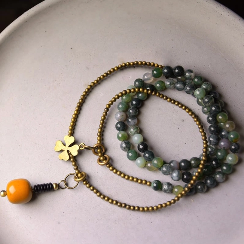 Stacked moss agate and copper multilayer bracelet set flat lay showing vintage brass chain design and mixed natural stone beads