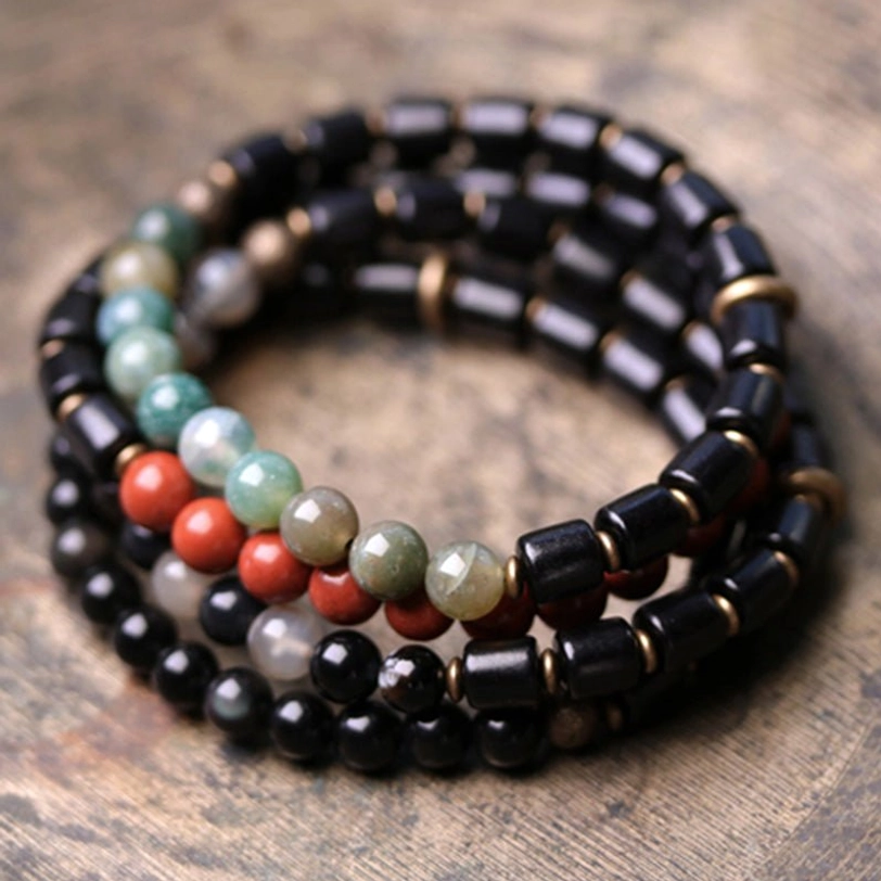Moss agate beaded bracelet with gradient green beads alternating with ebony wood and metal copper spacers flat lay