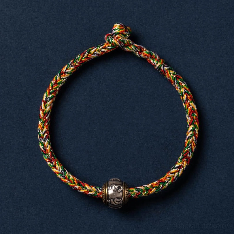 Multicolored Om Mani Padme Hum Tibetan bracelet with colorful thread accents and silver charm