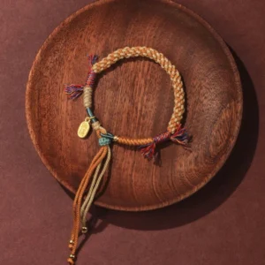 Adjustable Nafu luck bracelet with long tassel straps and gold fortune pendant, artisanal Tibetan design