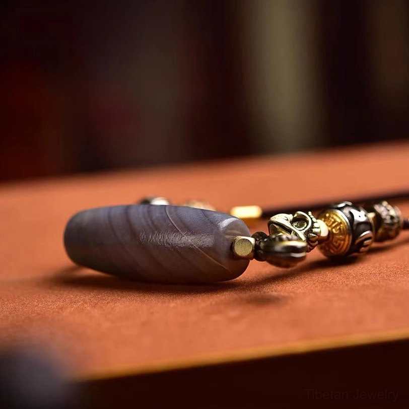 Banded grey agate dzi bead with mixed metal decorative beads and spiritual charm accessories