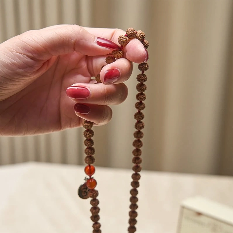 Handmade tibetan bodhi seed prayer beads close-up showing natural texture and red counter beads