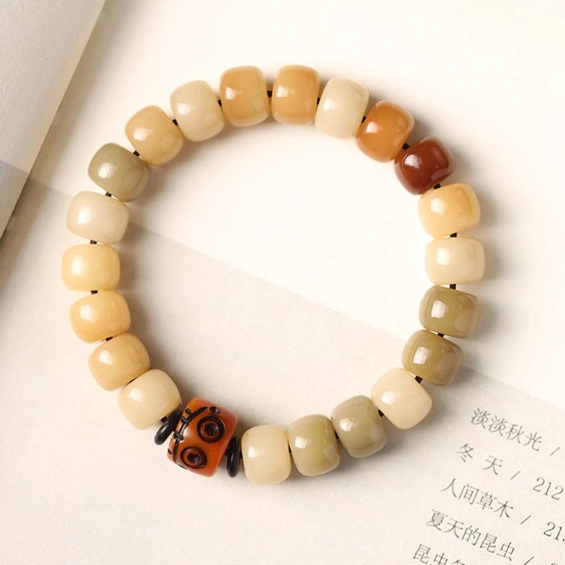 Natural bodhi seed spiritual practice bracelet, overhead view featuring warm earth tone barrel beads and decorative metal accent detail
