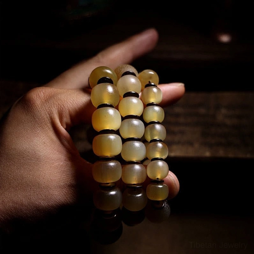 Natural yellow sheep horn Om Mani bracelet showing unisex design and comfortable fit on wrist