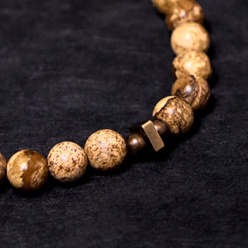 Detailed macro flat lay of natural stone beads with copper spacer beads, patterned stone texture