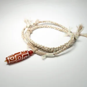 Nine-eye Tibetan dzi bead protection bracelet with double-layer braided rope detail, oblique angle