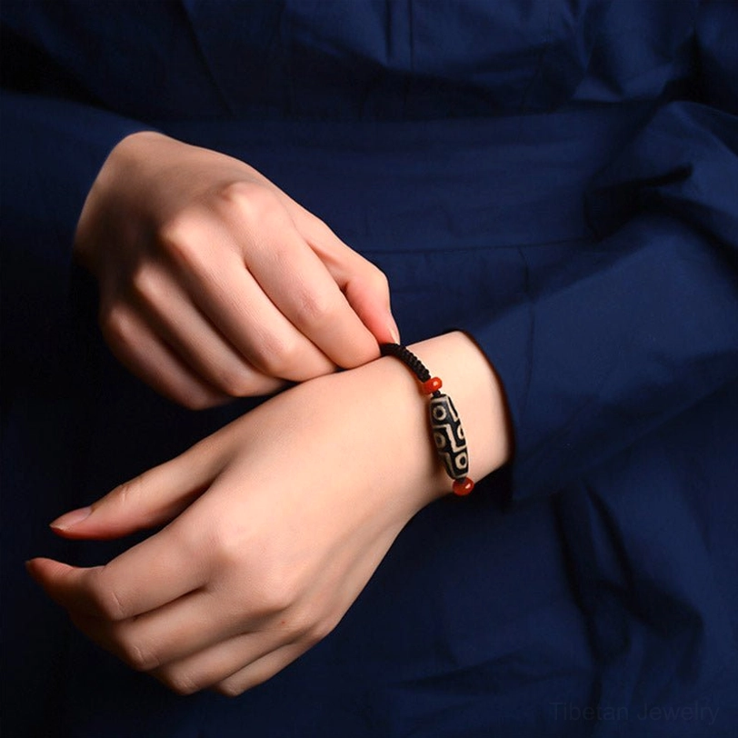 Person wearing Nine-Eye Dzi bracelet on wrist, lifestyle close-up showing comfortable fit and authentic wear