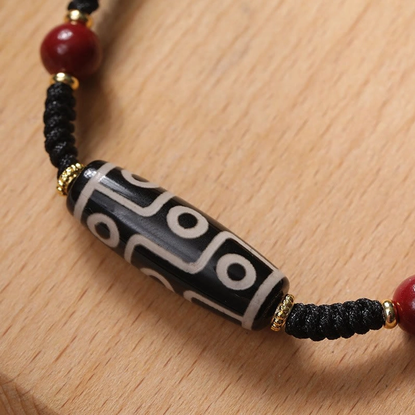 Nine-eye dzi bead protection bracelet side view detail showing authentic pattern and gold metal spacers