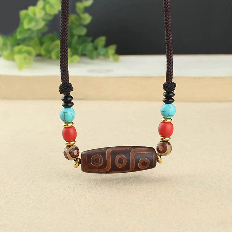 Tibetan nine-eye dzi bead necklace close-up showing hand-painted agate stone detail and intricate eye pattern markings