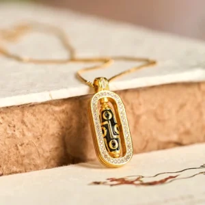 24K gold plated nine-eye dzi bead pendant with zircon frame on vintage paper background, flat lay close-up view